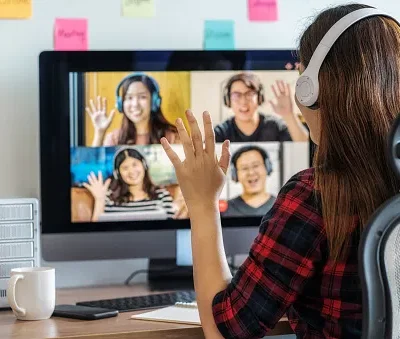 rear view of asian business woman say hello with teamwork colleague in video conference