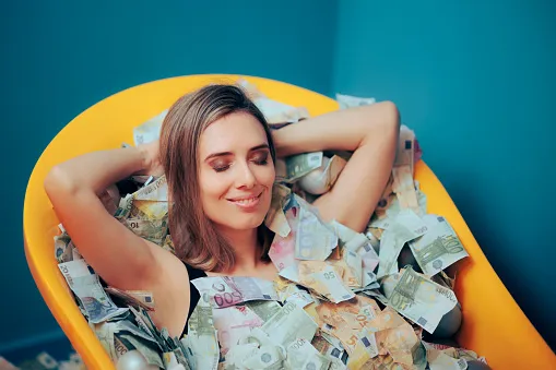 rich carefree woman bathing in a tub of money