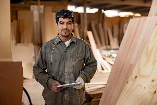 worker taking inventory of wood while working at a lumberyard